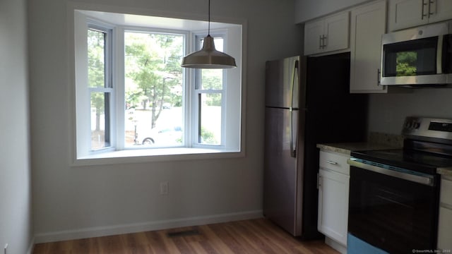 4 Rosewood Cir Unit 4, Monroe, CT 06468 - kitchen featuring stainless steel appliances, light wood-type flooring, hanging light fixtures, and white cabinetry