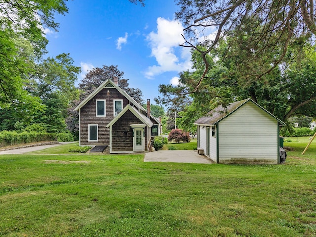18 Cards Mill Rd, Columbia, CT 06237 - rear view of house with a chimney, a yard, a patio, and an outbuilding