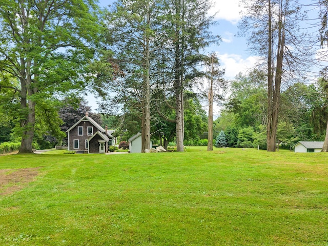 18 Cards Mill Rd, Columbia, CT 06237 - view of green lawn with a storage unit and a garage