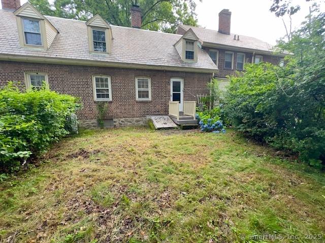 118 Sims St, Bridgeport, CT 06604 - back of property featuring a chimney, a yard, and brick siding