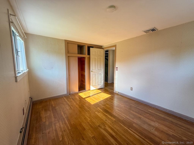 9 Meadow Brook Rd, Brookfield, CT 06804 - unfurnished bedroom featuring a baseboard heating unit, wood finished floors, and a closet