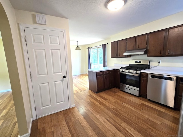 266 Cianci Rd, New Britain, CT 06053 - kitchen featuring stainless steel appliances, under cabinet range hood, a peninsula, and dark brown cabinetry