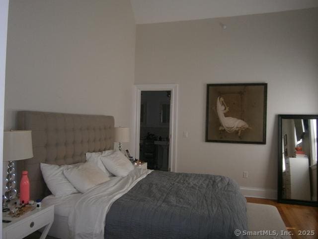 65 Sherwood Pl Unit 65, Greenwich, CT 06830 - bedroom featuring wood finished floors, lofted ceiling, and ensuite bath