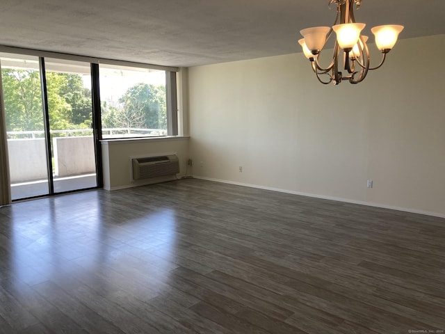 50 Birdseye St Unit 104, Stratford, CT 06615 - spare room featuring a wall mounted AC, a chandelier, and dark wood-style floors