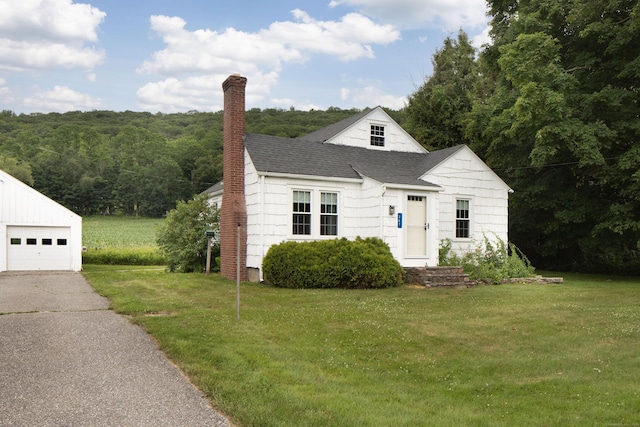 367 Norfolk Rd, North Canaan, CT 06024 - view of front facade with a chimney, a front lawn, roof with shingles, driveway, and an outbuilding
