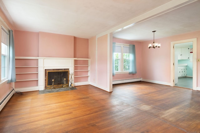 367 Norfolk Rd, North Canaan, CT 06024 - unfurnished living room with a baseboard radiator, wood finished floors, a chandelier, and a fireplace with flush hearth