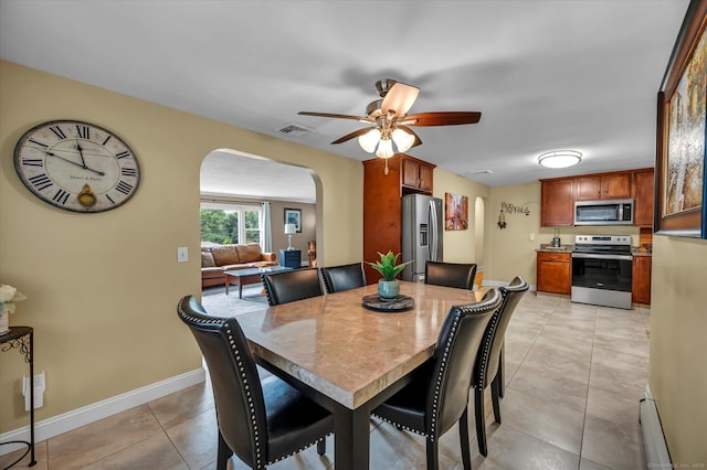 266 Ballfall Rd, Middletown, CT 06457 - dining space with arched walkways, a ceiling fan, a baseboard radiator, and light tile patterned floors
