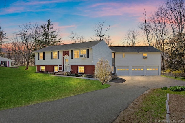 31 Bob White Way, Plainfield, CT 06354 - split foyer home featuring asphalt driveway, a garage, a lawn, and an outdoor structure