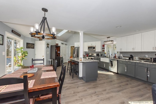 31 Bob White Way, Plainfield, CT 06354 - kitchen featuring stainless steel appliances, a chandelier, vaulted ceiling, backsplash, and a center island