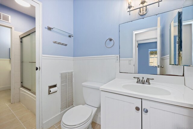 1060 New Haven Ave Apt 7, Milford, CT 06460 - bathroom featuring a wainscoted wall, vanity, tile patterned flooring, and shower / bath combination with glass door