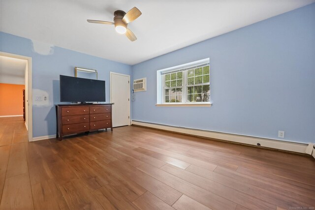 1060 New Haven Ave Apt 7, Milford, CT 06460 - unfurnished bedroom with a baseboard heating unit, dark wood-style flooring, a wall mounted AC, and a ceiling fan