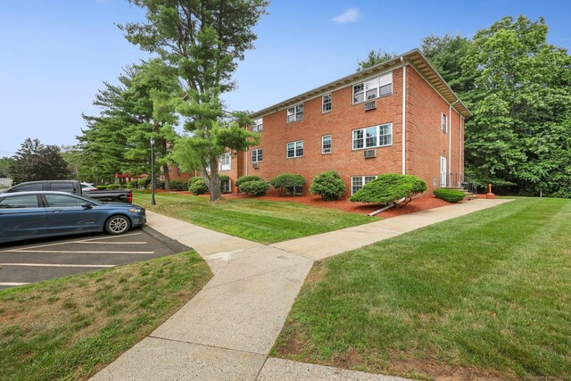 1060 New Haven Ave Apt 7, Milford, CT 06460 - view of home's exterior featuring uncovered parking, brick siding, and a yard