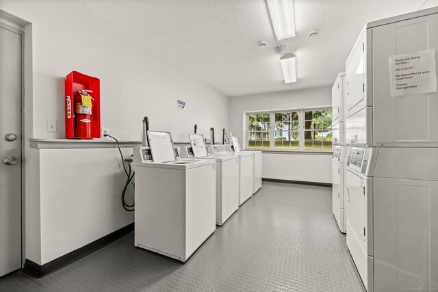 1060 New Haven Ave Apt 7, Milford, CT 06460 - communal laundry room featuring stacked washing machine and dryer, tile patterned floors, a textured ceiling, and washer and clothes dryer