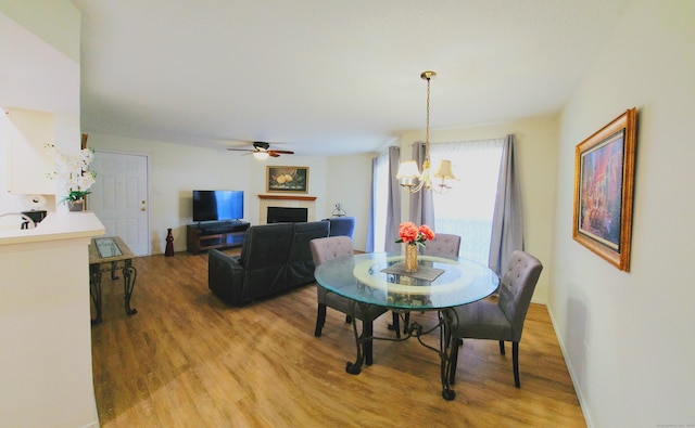 59 Leafwood Ln Apt 275, Groton, CT 06340 - dining room with light wood-style flooring, a chandelier, a fireplace, and a ceiling fan