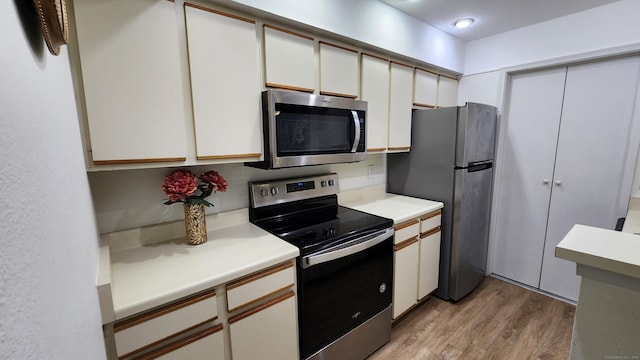 59 Leafwood Ln Apt 275, Groton, CT 06340 - kitchen with appliances with stainless steel finishes, light countertops, light wood-type flooring, and white cabinets