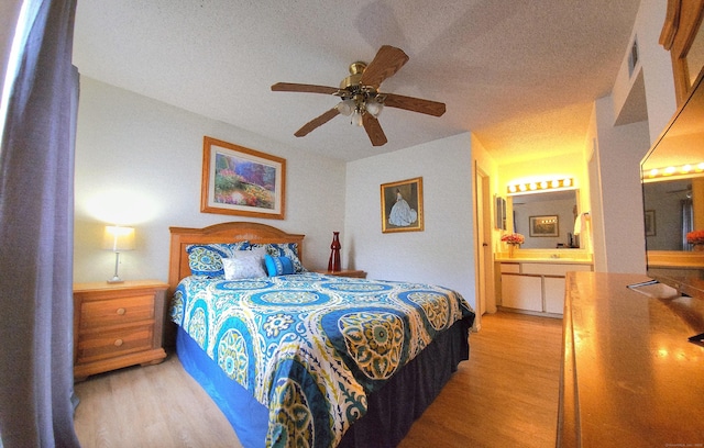 59 Leafwood Ln Apt 275, Groton, CT 06340 - bedroom featuring light wood-type flooring, connected bathroom, a textured ceiling, and a ceiling fan