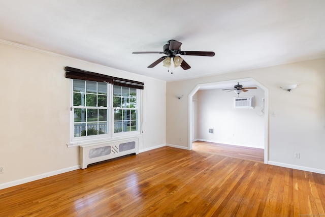 6 French St, Bristol, CT 06010 - empty room featuring a ceiling fan, light wood-style floors, radiator heating unit, and a wall unit AC