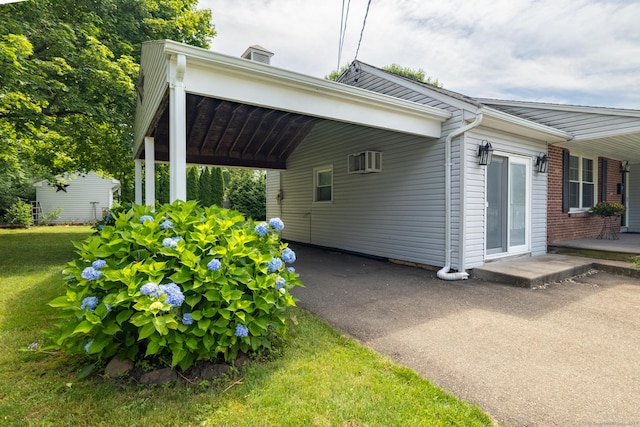 6 French St, Bristol, CT 06010 - view of side of home featuring an attached carport, a yard, an AC wall unit, and asphalt driveway