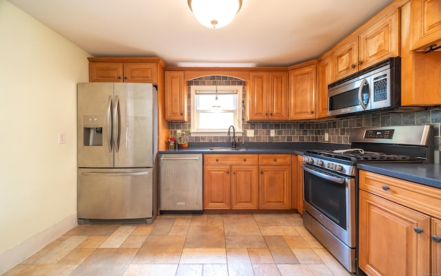 44 Middle Tpke E, Manchester, CT 06040 - kitchen featuring stainless steel appliances, dark countertops, backsplash, and brown cabinets