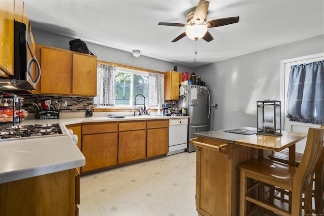 4 Warfield St, Milford, CT 06461 - kitchen with stainless steel appliances, ceiling fan, light countertops, brown cabinetry, and decorative backsplash