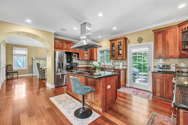 19 Woodlawn Dr, Trumbull, CT 06611 - kitchen with stainless steel appliances, island exhaust hood, a kitchen island, arched walkways, and dark wood-style floors