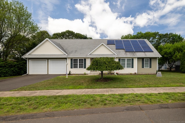 130 Bird Rd, Bristol, CT 06010 - ranch-style home featuring an attached garage, driveway, roof mounted solar panels, a front lawn, and roof with shingles