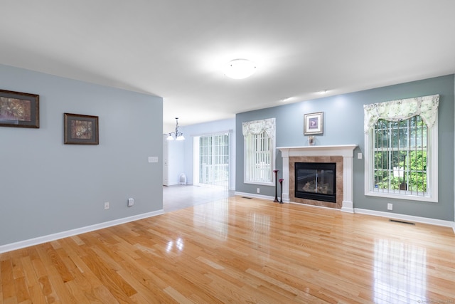 130 Bird Rd, Bristol, CT 06010 - unfurnished living room featuring a chandelier, light wood-type flooring, and a tile fireplace