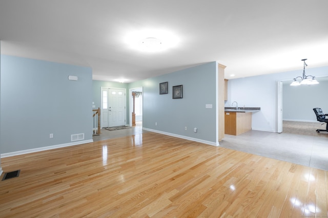 130 Bird Rd, Bristol, CT 06010 - unfurnished living room featuring light wood finished floors and a chandelier