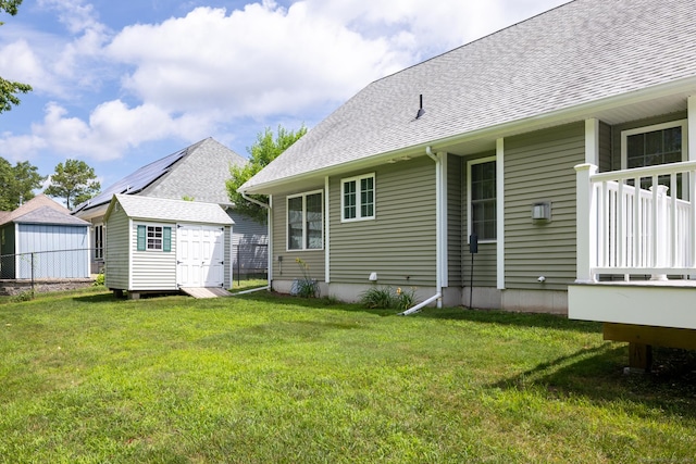 130 Bird Rd, Bristol, CT 06010 - back of house with a storage shed, a shingled roof, and a lawn