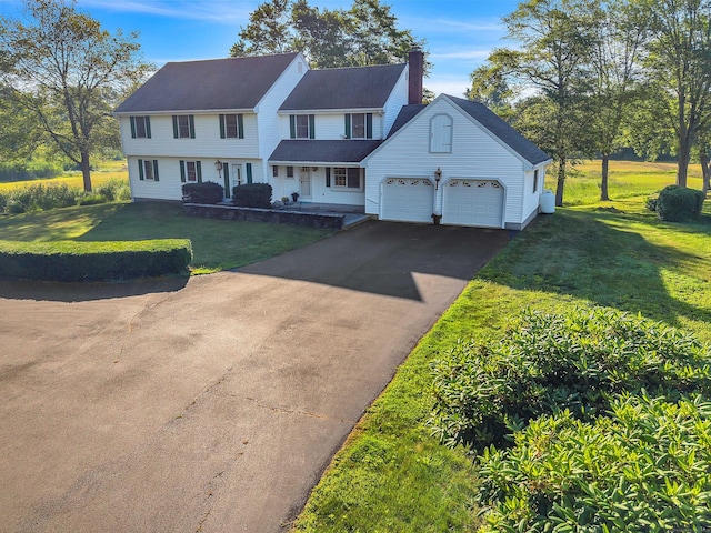7 Sharon Ln, Old Saybrook, CT 06475 - view of front of property featuring driveway, a chimney, a front lawn, and an attached garage