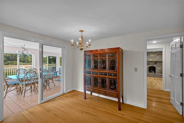 7 Sharon Ln, Old Saybrook, CT 06475 - dining room with a chandelier, light wood finished floors, a fireplace, and recessed lighting