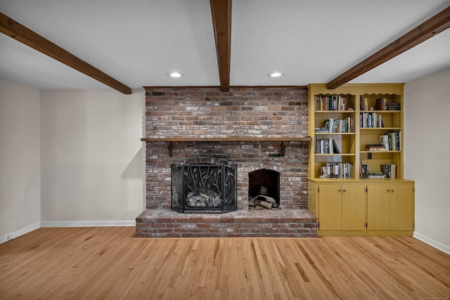 7 Sharon Ln, Old Saybrook, CT 06475 - unfurnished living room featuring beam ceiling, a brick fireplace, wood finished floors, a textured ceiling, and recessed lighting