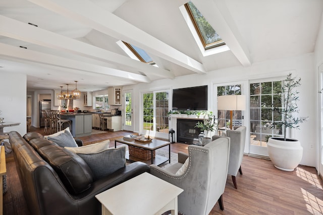 64 Red Top Dr, West Hartford, CT 06110 - living area with a skylight, a chandelier, a glass covered fireplace, and wood finished floors