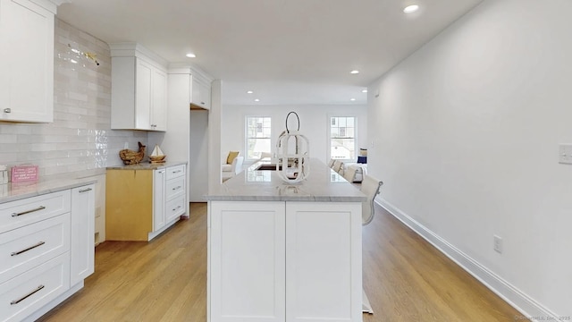 12 Woodland Dr, Milford, CT 06460 - kitchen with light wood-style floors, white cabinetry, recessed lighting, decorative backsplash, and light stone counters