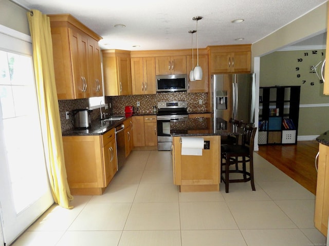 17 Ridge View Ter, New Hartford, CT 06057 - kitchen featuring appliances with stainless steel finishes, tasteful backsplash, a kitchen breakfast bar, a kitchen island, and pendant lighting