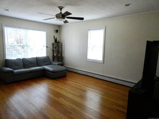 17 Ridge View Ter, New Hartford, CT 06057 - living room with baseboard heating, wood finished floors, healthy amount of natural light, ceiling fan, and a textured ceiling