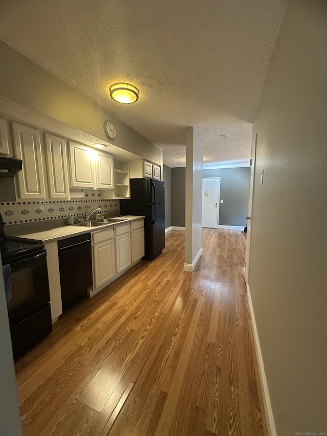 65 Horse Pond Rd Apt G, Salem, CT 06420 - kitchen featuring black appliances, light wood-style floors, white cabinets, a textured ceiling, and light countertops