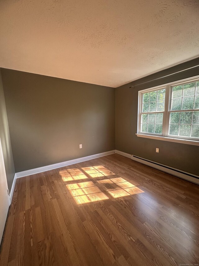 65 Horse Pond Rd Apt G, Salem, CT 06420 - unfurnished room featuring a textured ceiling, a baseboard radiator, and wood finished floors