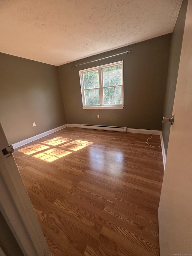 65 Horse Pond Rd Apt G, Salem, CT 06420 - unfurnished room featuring a baseboard radiator, a textured ceiling, and wood finished floors