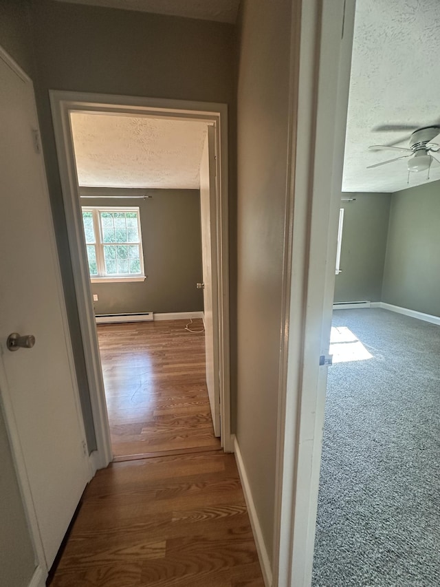 65 Horse Pond Rd Apt G, Salem, CT 06420 - corridor with a baseboard heating unit, a textured ceiling, and wood finished floors