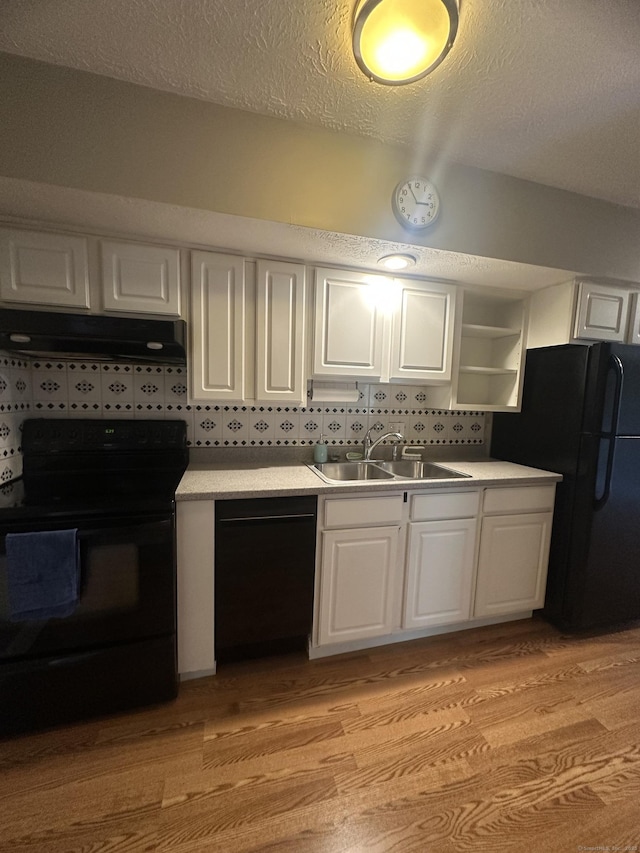 65 Horse Pond Rd Apt G, Salem, CT 06420 - kitchen featuring black appliances, under cabinet range hood, white cabinets, light wood-style floors, and light countertops