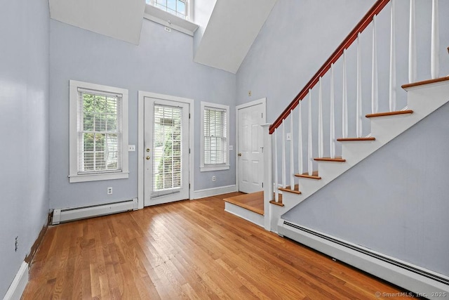 88 Powder Hill Rd, Middlefield, CT 06455 - entryway with a baseboard heating unit, a towering ceiling, wood finished floors, and stairs