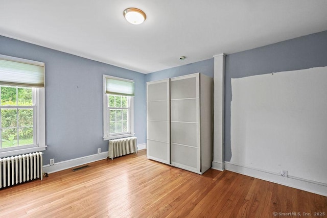 88 Powder Hill Rd, Middlefield, CT 06455 - unfurnished bedroom featuring radiator, multiple windows, and wood finished floors