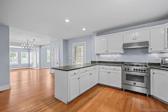 88 Powder Hill Rd, Middlefield, CT 06455 - kitchen featuring stainless steel stove, under cabinet range hood, a peninsula, a chandelier, and white cabinets