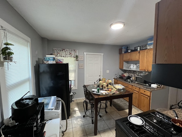 141 County St, New Haven, CT 06511 - kitchen with gas range oven, light tile patterned floors, brown cabinetry, and decorative backsplash