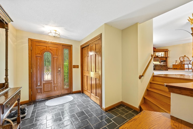 foyer with stone tile flooring and a textured ceiling