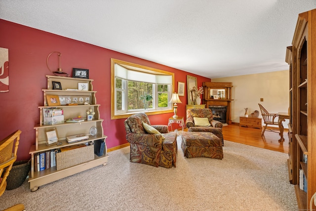 carpeted living room with a fireplace and a textured ceiling
