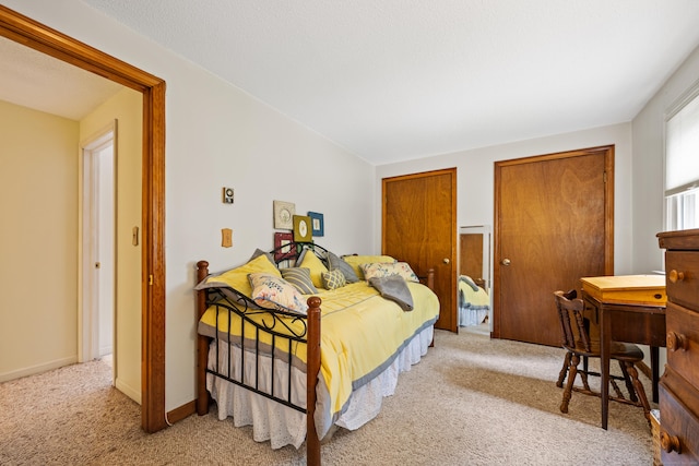 bedroom featuring carpet and two closets