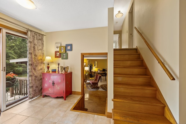 staircase with tile patterned flooring and a textured ceiling