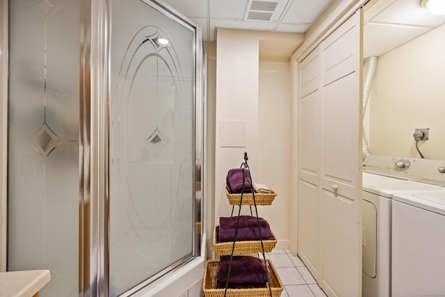 full bathroom featuring washer and dryer, tile patterned floors, and a shower stall